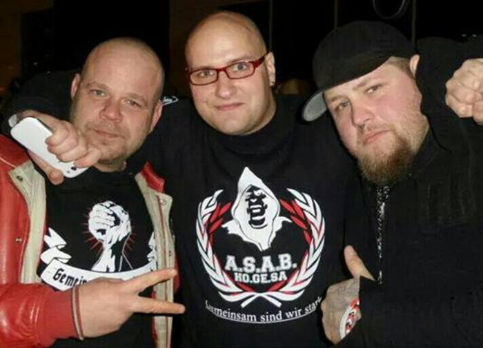 Auf einer Kundgebung gegen Geflüchtete 2015 in Berlin posiert eine Führungsperson des (kurzlebigen) neonazistischen Bündnis Deutscher Hools (Bildmitte) mit den Musikern des neonazistischen Liedermacher-Duos A3stus.