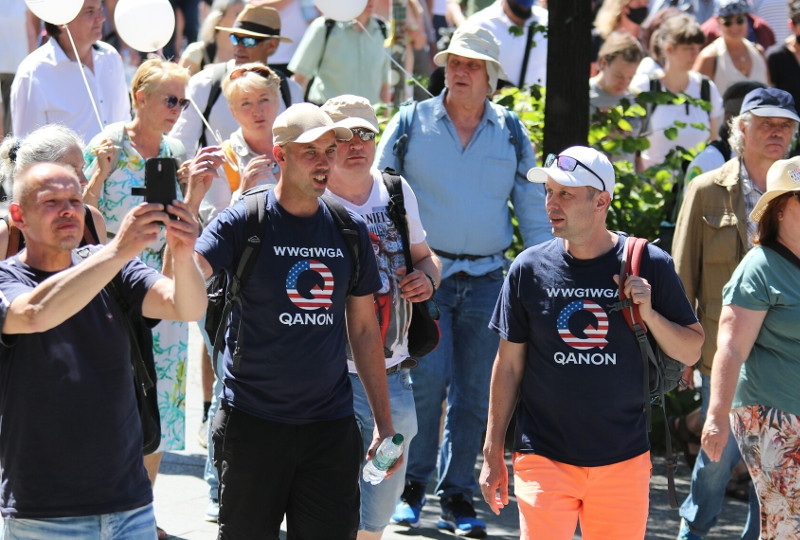 Teilnehmende der Demonstration gegen die Maßnahmen zur Eindämmung der Corona-Pandemie am 01. August 2020 in Berlin. In der Symbolik von QAnon gibt es zahlreiche Verweise auf die Populärkultur. Der QAnon-Slogan »Where we go one we go all«, abgekürzt WWG1WGA, wurde dem Spielfilm »White Squall« von 1996 (dt: White Squall – Reißende Strömung) des Regisseurs Ridley Scott entnommen. Der Film erzählt die Geschichte des Segelschulschiffes »Albatross«, das in einem Sturm kentert. »Where we go one we go all« befindet sich als Gravur auf der Schiffsglocke. Im Mittelpunkt der Handlung steht der selbstlose Kampf der Crew-Mitglieder, die sich gegen den Untergang stemmen. So soll der Spruch den Zusammenhalt einer verschworenen Gemeinschaft ausdrücken.