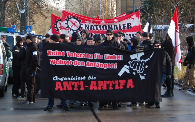 Bild: Neonazistischer Aufmarsch in Sulzbach-Rosenberg, einem Ort in der Oberpfalz, 50 km östlich von Nürnberg, im Jahr 2010. Der Großraum Nürnberg ist seit vielen Jahren ein Schwerpunkt von Aktivitäten der Anti-Antifa. Auf einer eigens eingerichteten Homepage veröffentlichte die »Anti-Antifa Nürnberg« (Stand 2017) über 200 AntifaschistInnen, GewerkschafterInnen, JournalistInnen und LehrerInnen teils mit Namen, Adresse und Bild. Gegen etliche Personen, die dort öffentlich gemacht wurden, gab es Drohungen und Sachbeschädigungen an deren Wohnhäusern und Kraftfahrzeugen bis hin zu Brandanschlägen.

siehe auch: Jonas Miller: Anschläge der »Anti-Antifa«, in: der rechte rand 166, Mai 2017
https://www.der-rechte-rand.de/archive/2613/nuernberg-anti-antifa/