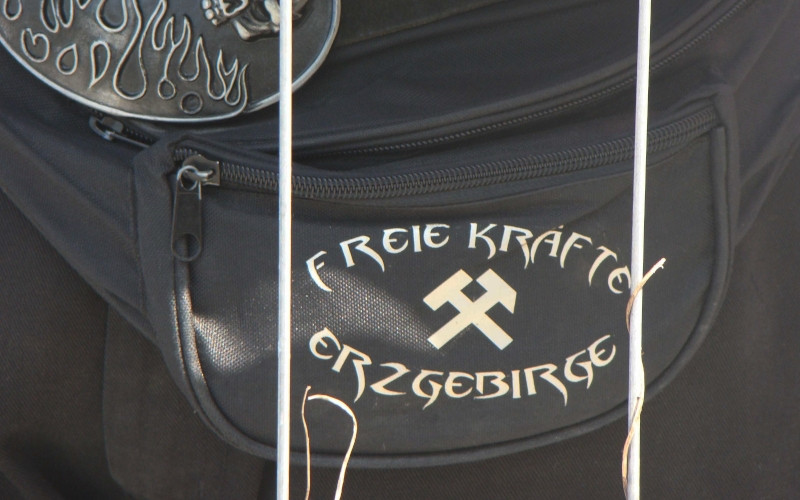 Angehörige neonazistischer Kameradschaften sind häufig mit »ihrer« Kameradschafts-Symbolik ausstaffiert. Das Logo der Kameradschaft befindet sich meist auf Shirts, Jacken und Mützen und bisweilen auch auf Bauchtaschen und Schlüsselbändern.
Das Symbol der Freien Kräfte Erzgebirge zeigt mittig Schlägel und Eisen, das international gebräuchliche Symbol für den Bergbau. Verwechslungsgefahr besteht mit den zwei gekreuzten Zimmermannshämmern der Hammerskins.