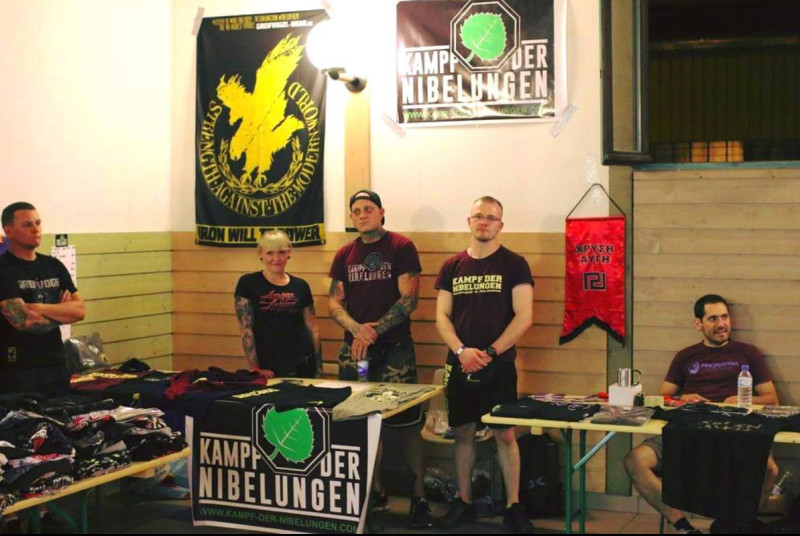 Über Soziale Medien verbreitetes Promotionsbild von Kampf der Nibelungen. Es zeigt den Verkaufsstand von »Kampf der Nibelungen« und Greifvogel Wear bei einer neonazistischen Kampfsport-Veranstaltung am 10.06.2017 in Frankreich. Rechts im Bild der Stand des neonazistischen griechischen »Pro Patria Fight Club«.