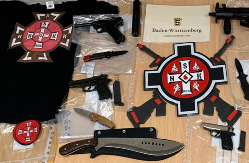 Das Landeskriminalamt Baden-Württemberg präsentierte nach den Razzien im Januar 2019 gegen Mitglieder der  »National Social Knights of the Ku-Klux-Klan Deutschland«  einen Teil der beschlagnahmten Waffen und Gruppenkennzeichen.