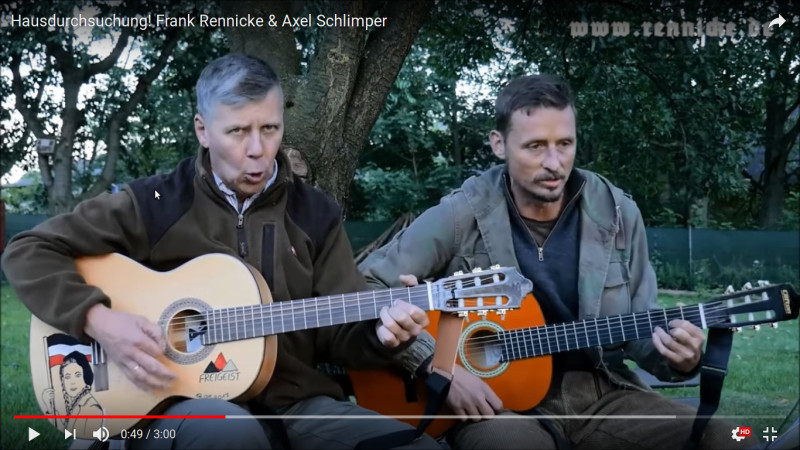 Zusammen mit Axel Schlimper, einem Funktionär der Europäischen Aktion, tritt Frank Rennicke - vor allem in Youtube-Videos - als Liedermacher-Duo auf. Das Bild zeigt einen Screenshot aus dem Video des Liedes »Hausdurchsuchung Razzia«, ein linkes Protestlied aus den 1980er Jahren, das von den beiden Neonazis gecovert wurde.