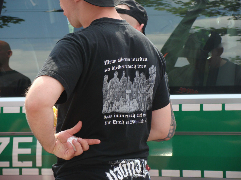 Das Shirt-Motiv zitiert die Anfangsstrophe der Liedes »Wenn alle untreu werden«: »Wenn alle untreu werden, so bleiben wir doch treu. Dass immer noch auf Erden für euch ein Fähnlein sei.«. Das 1814 verfasste Lied diente in der NS-Zeit der SS als »Treuelied« bzw. »Staffellied«.