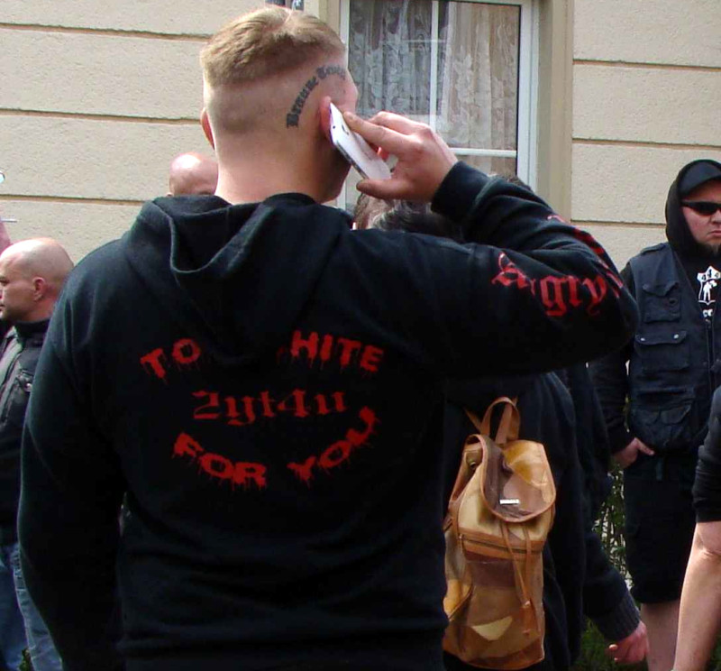 Fan-Shirt der US-amerikanischen Neonaziband Angry Aryans. Die Band veröffentlichte 2002 ihre CD "Too white for you", aus der sich der Code 2yt4u entwickelte. In dem Motiv wird die Decodierung gleich mit dazu geliefert - was dem Code seinen Sinngehalt nimmt und ihn zum reinen Stilelement macht.