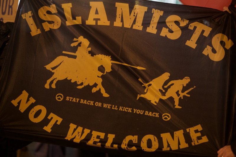 Ein Sinnbild des rechte Kampfes gegen den Islam ist der Kreuzritter. Auf dem Motiv »Islamists not welcome« treibt eine als Kreuzritter gezeichnete Figur mit seiner Lanze eine verschleierte Frau und einen bärtigen Mann mit Gewehr vor sich her. Verbreitet wird dieses Motiv insbesondere von der Identitären Bewegung, deren Lambda-Symbol auf diesem Transparent zu sehen ist.