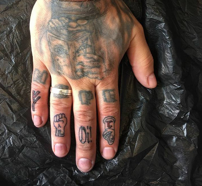 Die Tätowierungen zeigen (v.l.n.r.) die »Fehu«-Rune, die White-Power-Faust, den Schriftzug »Oi!« sowie ein Bandsymbol von Die Lunikoff Verschwörung.
