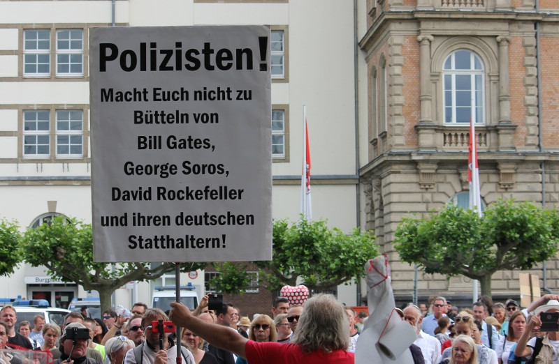 Teilnehmer einer Demonstration gegen die Maßnahmen aufgrund der Corona-Pandemie in Düsseldorf am 13. Juni 2020. Bemerkenswert ist, dass neben Bill Gates und George Soros noch David Rockefeller als vermeintlicher Drahtzieher benannt wird. Der 2017 verstorbene US-amerikanische Unternehmer war vor allem in den 1960er und 1970er Jahren von der US-amerikanischen Rechten angefeindet worden. Seine politischen Aktivitäten galten ihnen als »unamerikanisch« und sie bezichtigten ihn unter anderem, sowjetische Interessen zu vertreten.